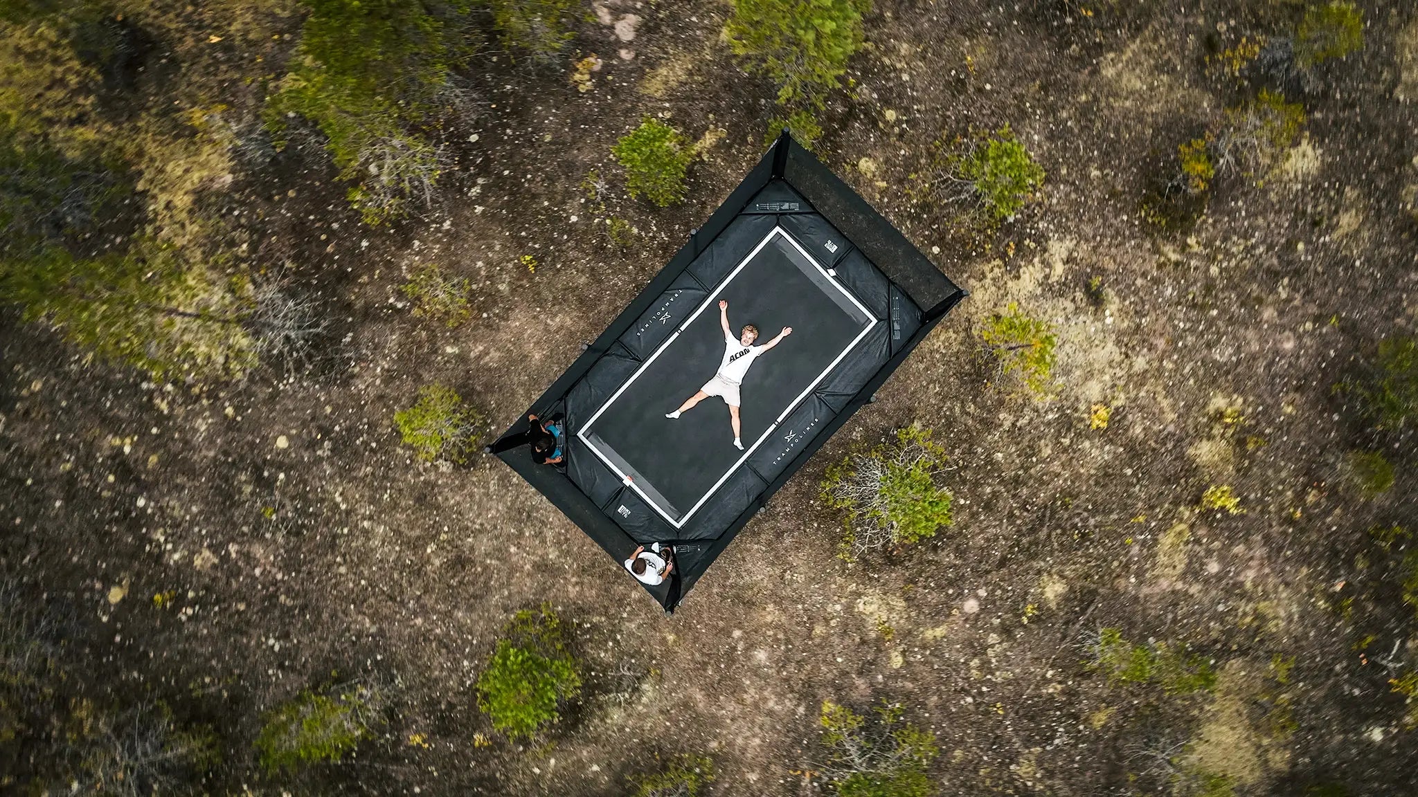Man lying on the Acon X trampoline in x-pose.