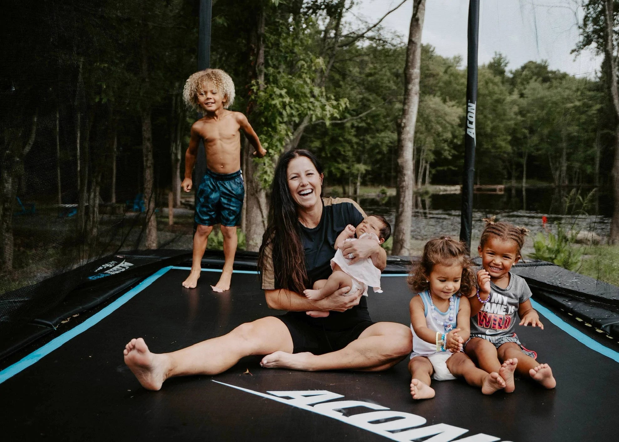 Mother with four children sitting and smiling on Acon HD trampoline