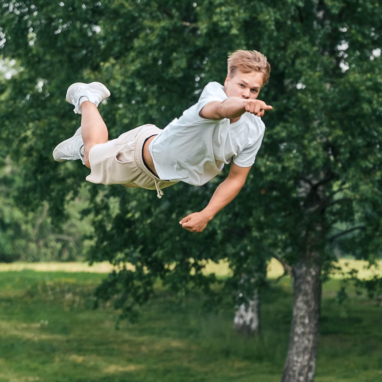 Boy flying in the air and pointing his finger.