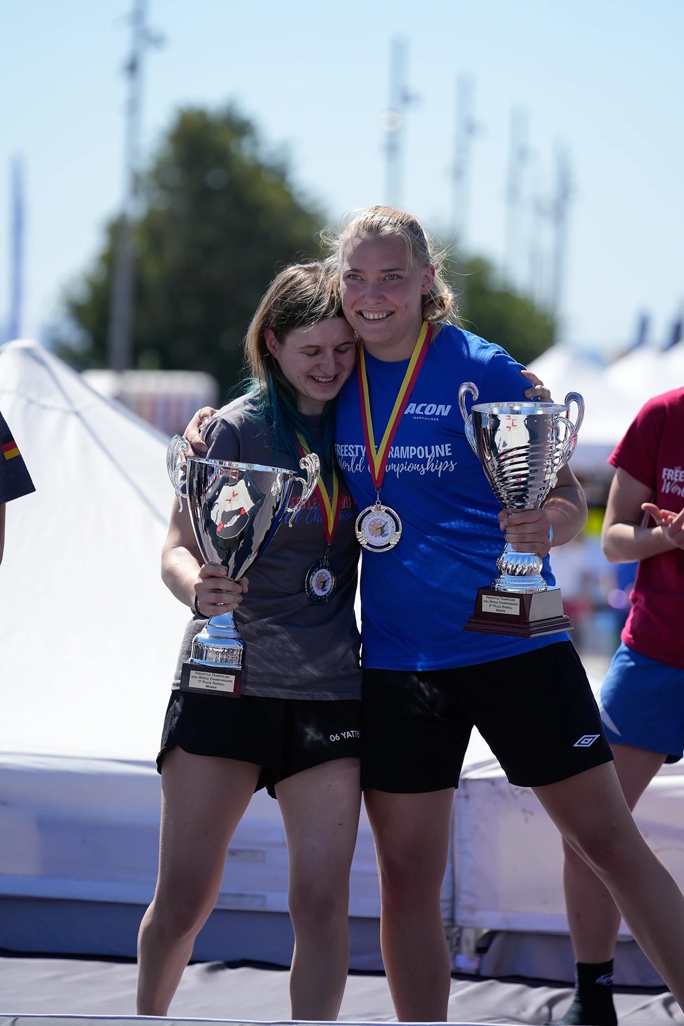 Trampoline contest winners hugging.