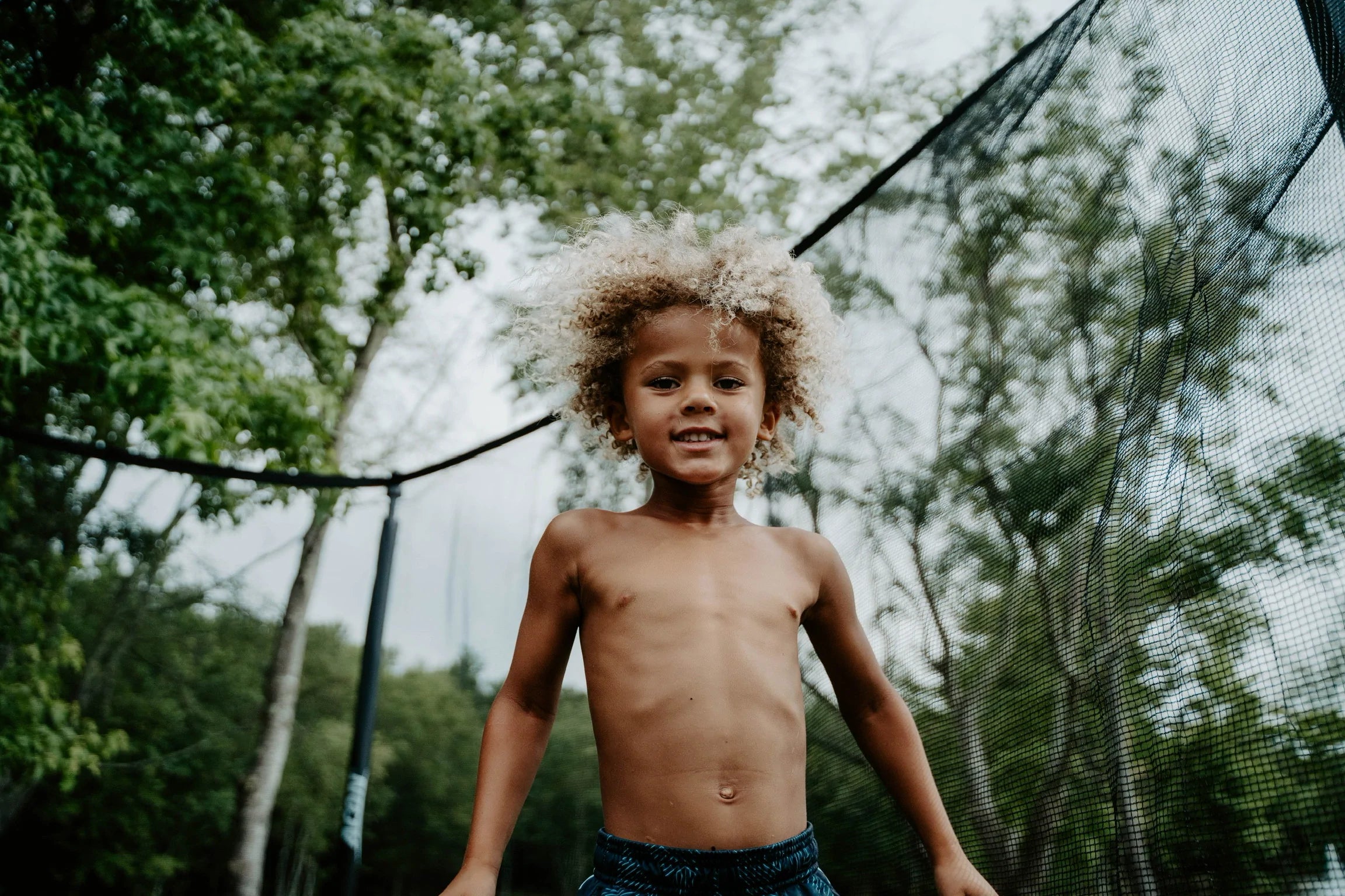 A smiling trampoline jumper kid