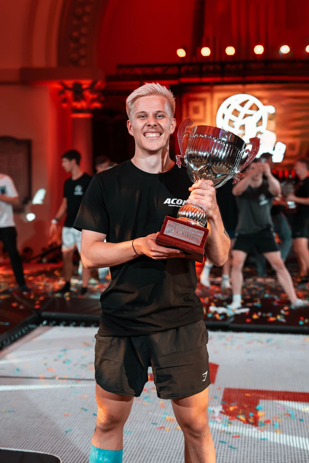 A smiling man holding his trophy.