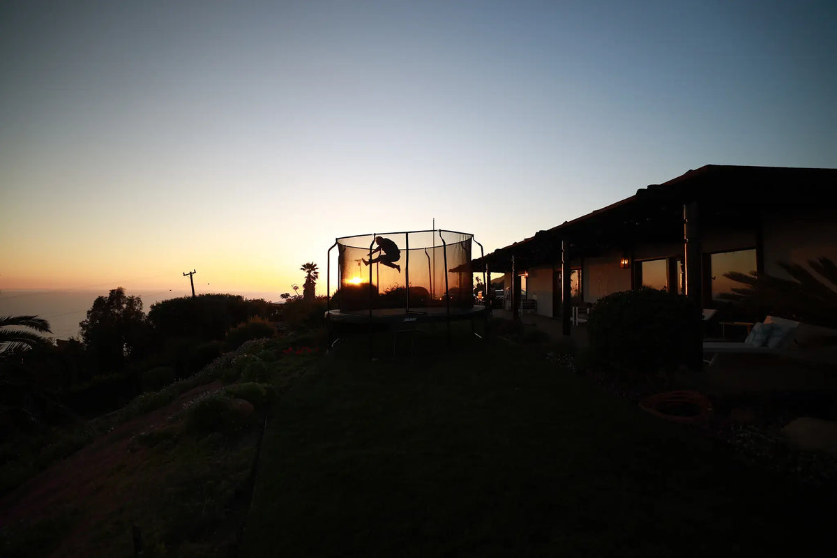 Peron jumping on a round Acon trampoline in beautiful sun set. 
