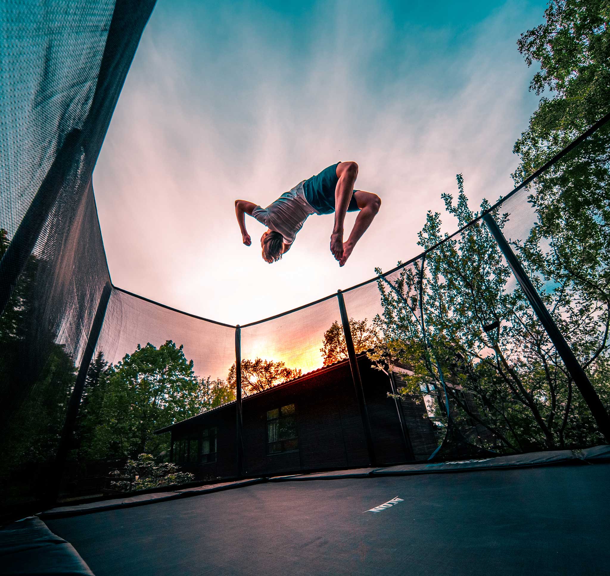 A boy doing a backflip on an Acon 16 HD trampoline