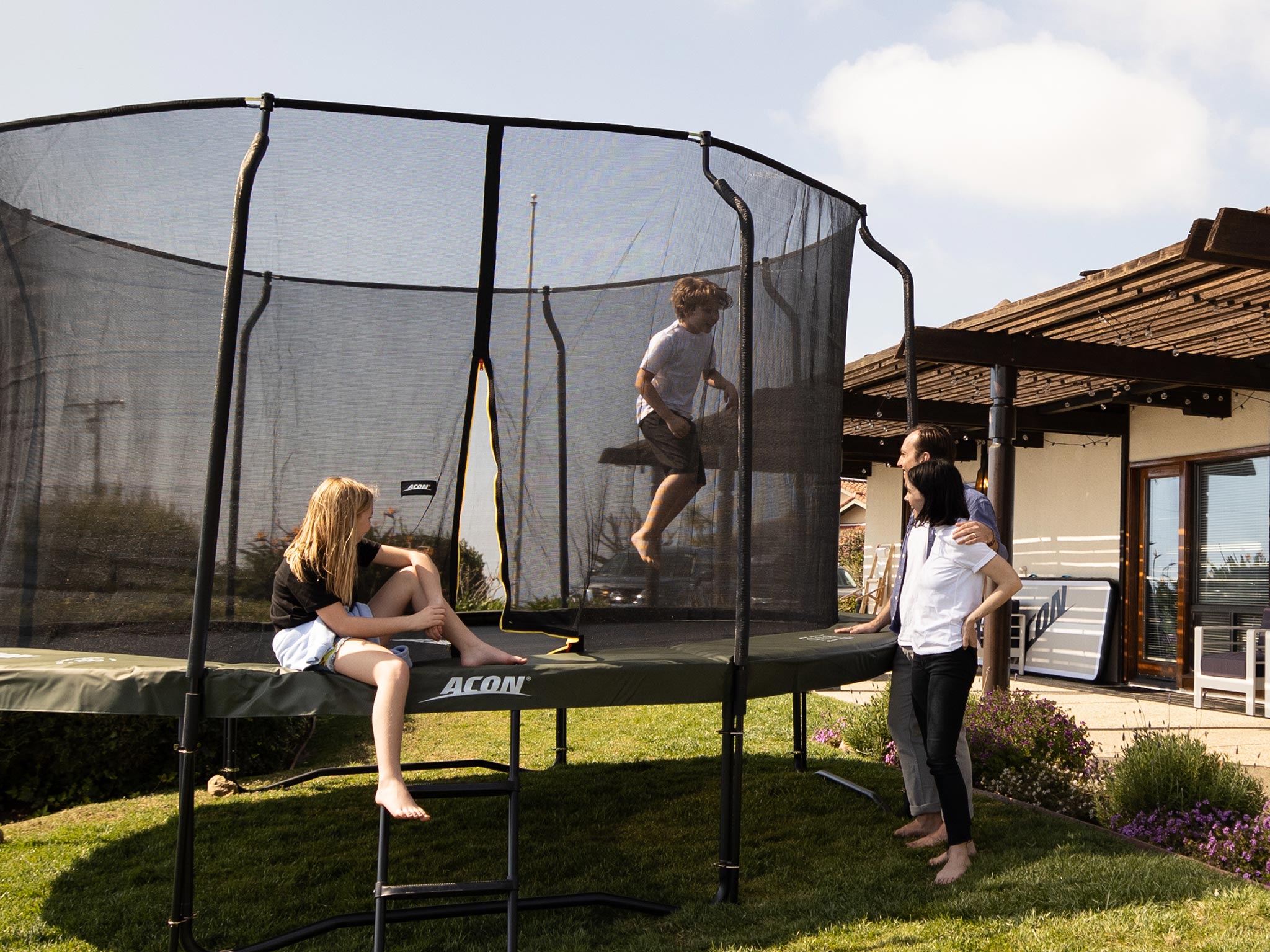Family watching kid on a trampoline