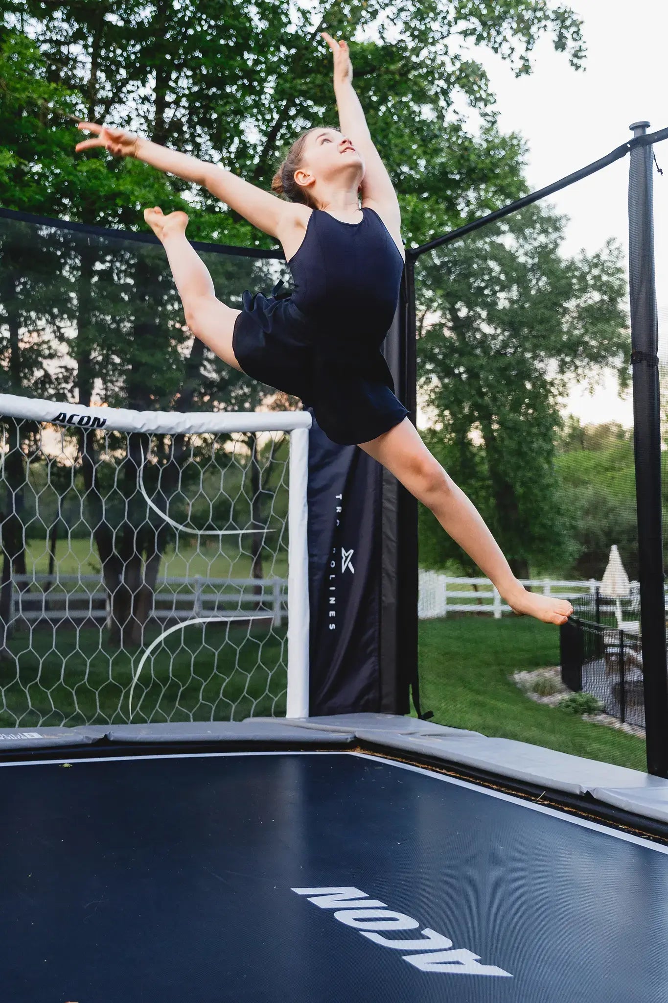 Girl doing a gymnastic jump on a Acon trampoline. 