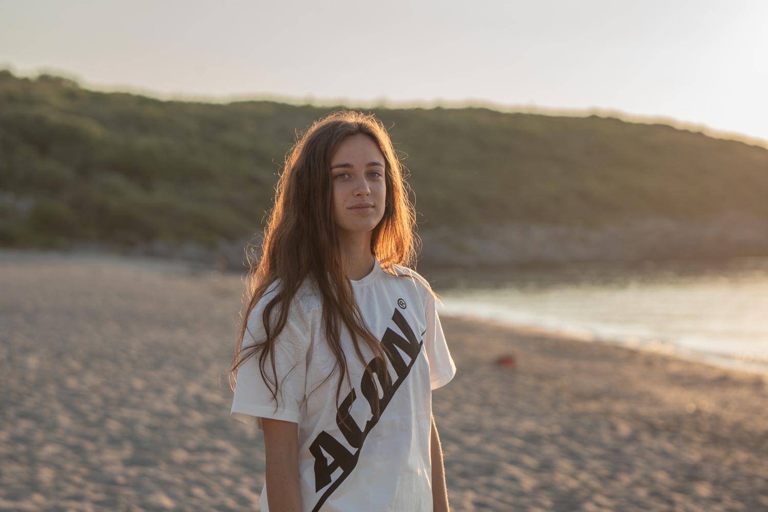 Girl on the beach wearing an Acon t-shirt