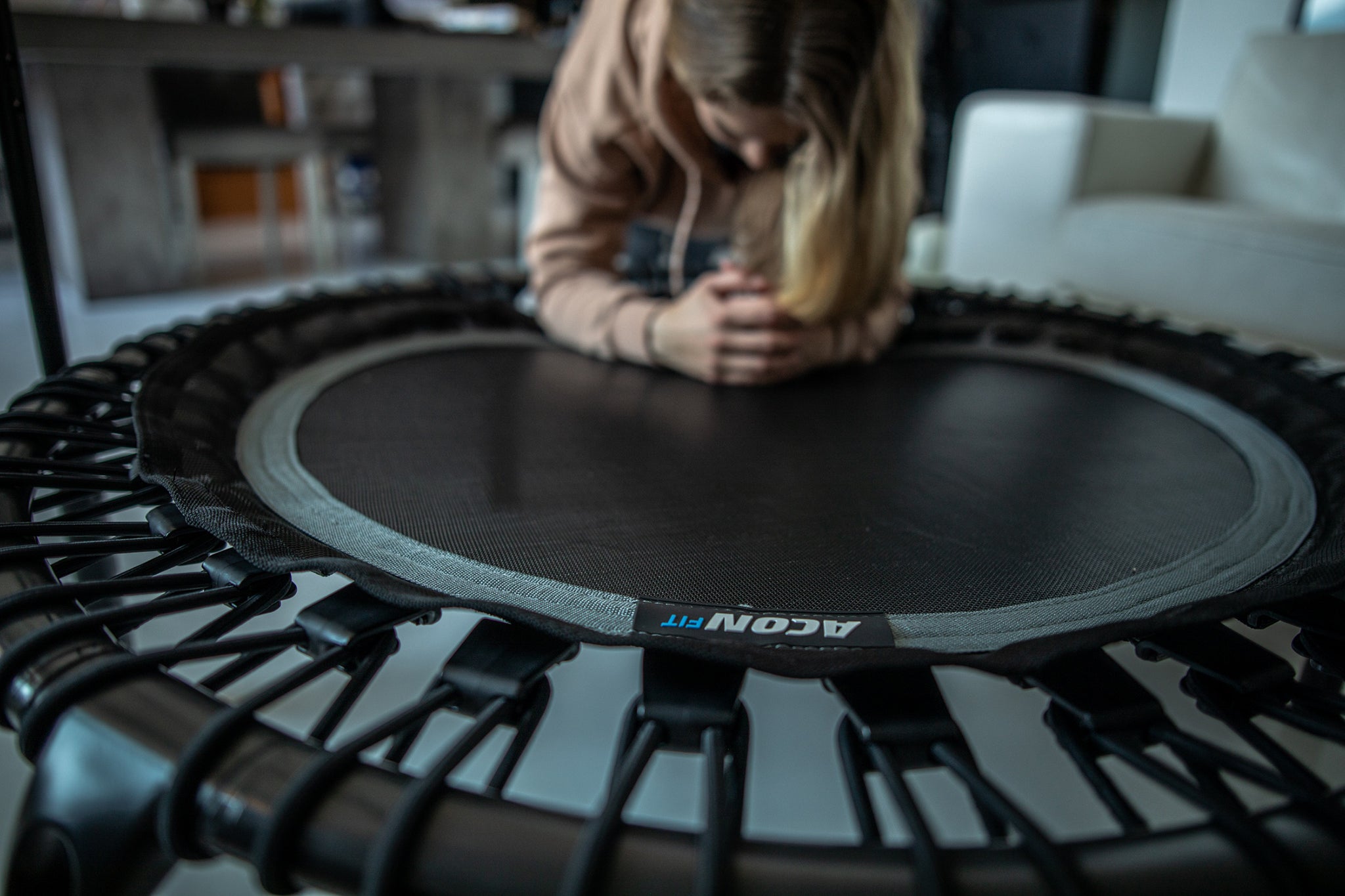 A woman planking on a black round Acon FIT Fitness trampoline