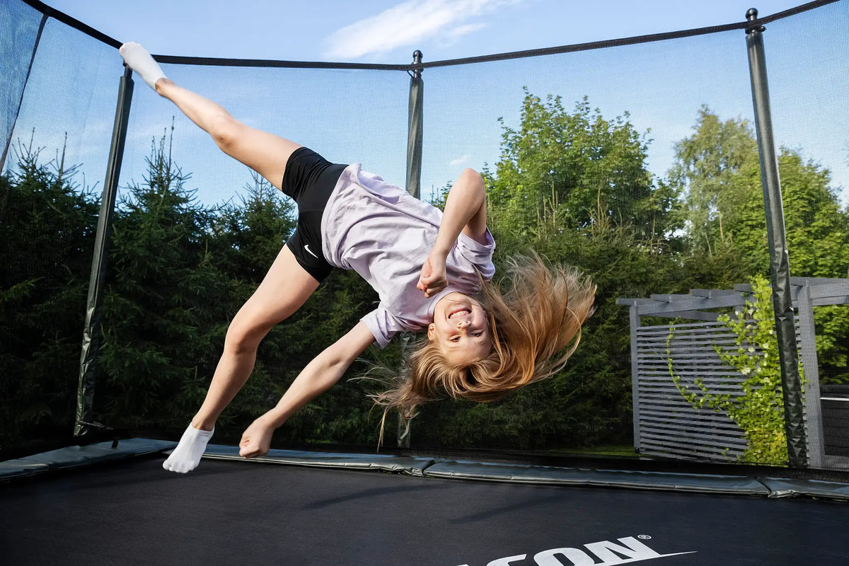 Girl practicing a trick on an Acon rectangular trampoline.
