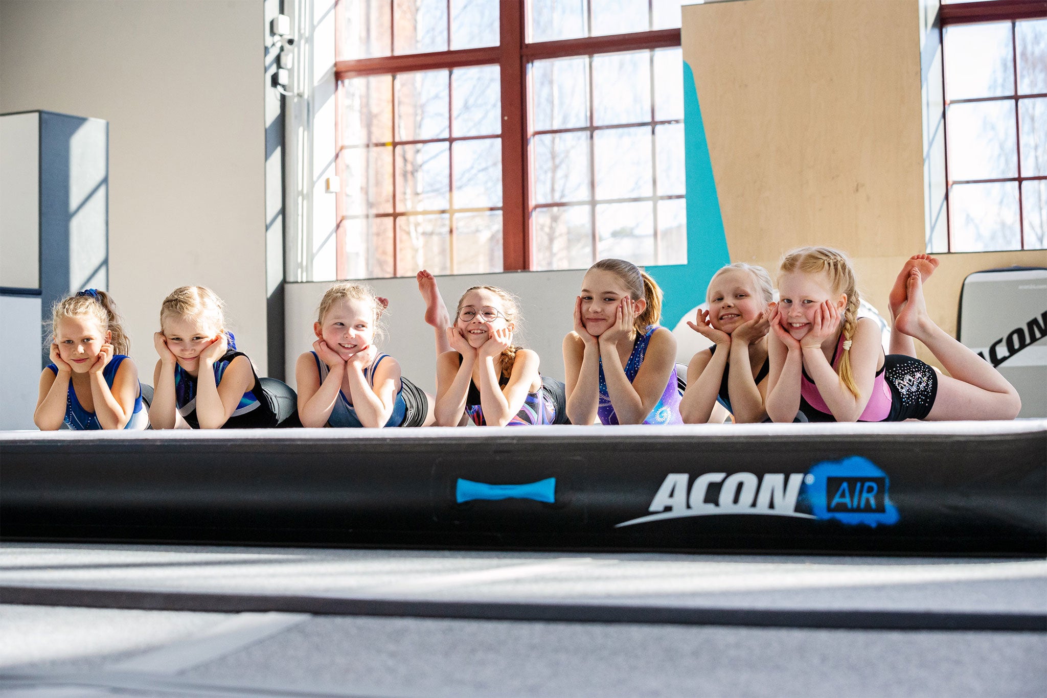 Young and happy gymnasts laying on ACON airtrack 