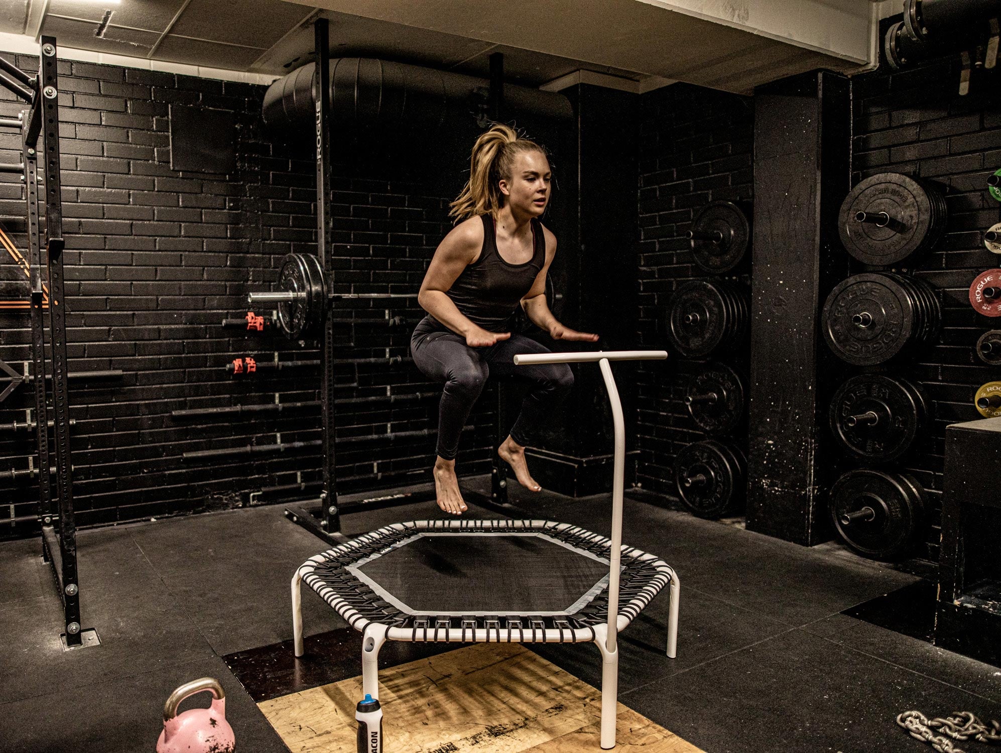 A woman on a Acon Fit Trampoline with Handlebar