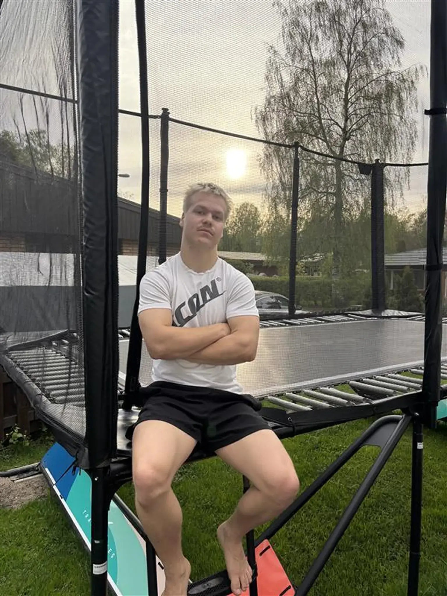 Trampolite athlete Leevi Valtonen sitting on an Acon trampoline. 