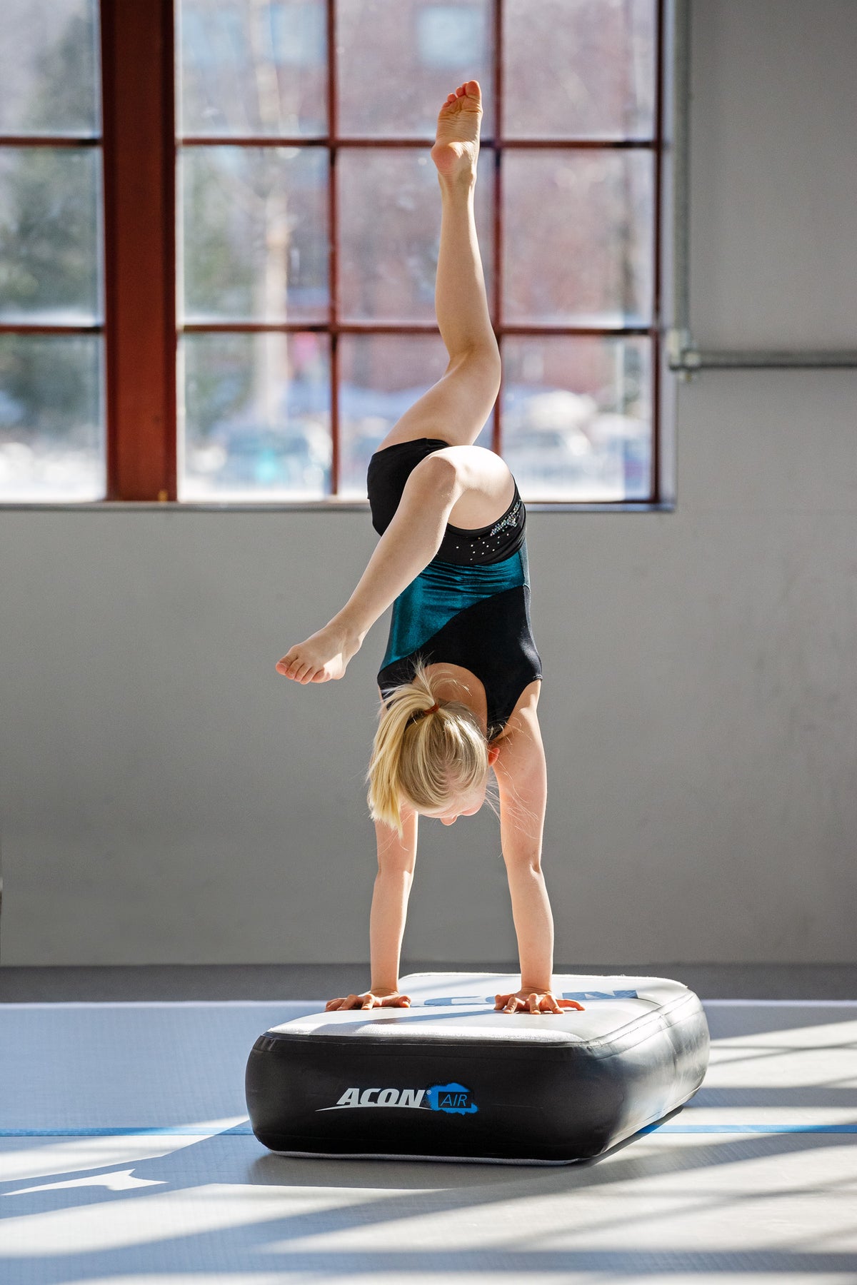 Woman doing a handstand on an Acon Airtblock.