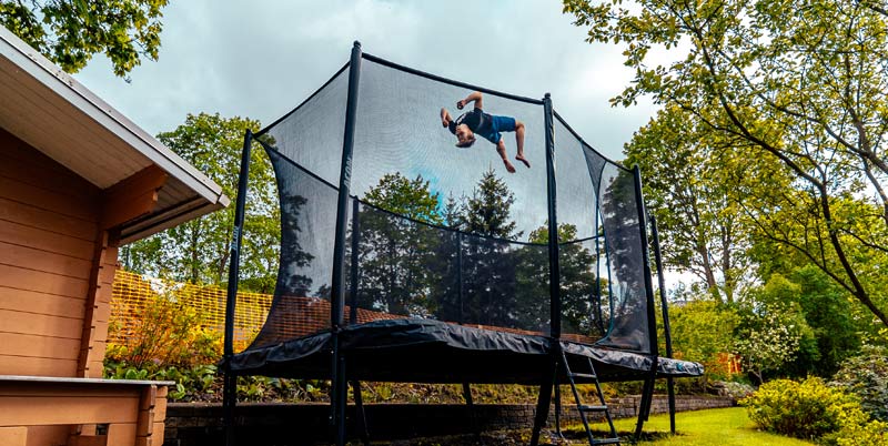 Acon HD Trampoline on a backyard. A tricker jumping on it.