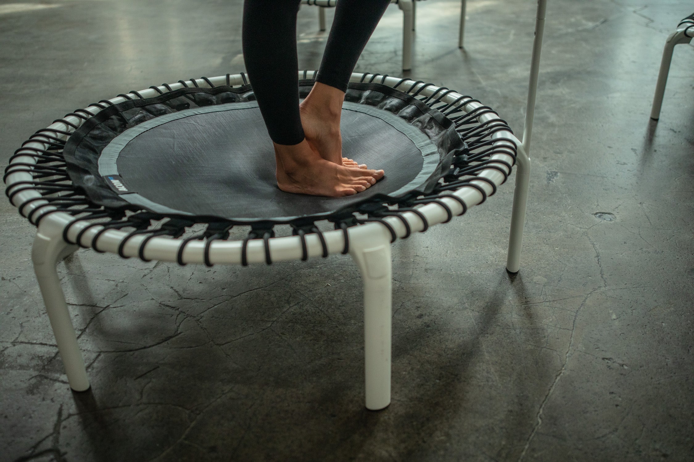 A woman standing on a rebounder trampoline. Closeup image