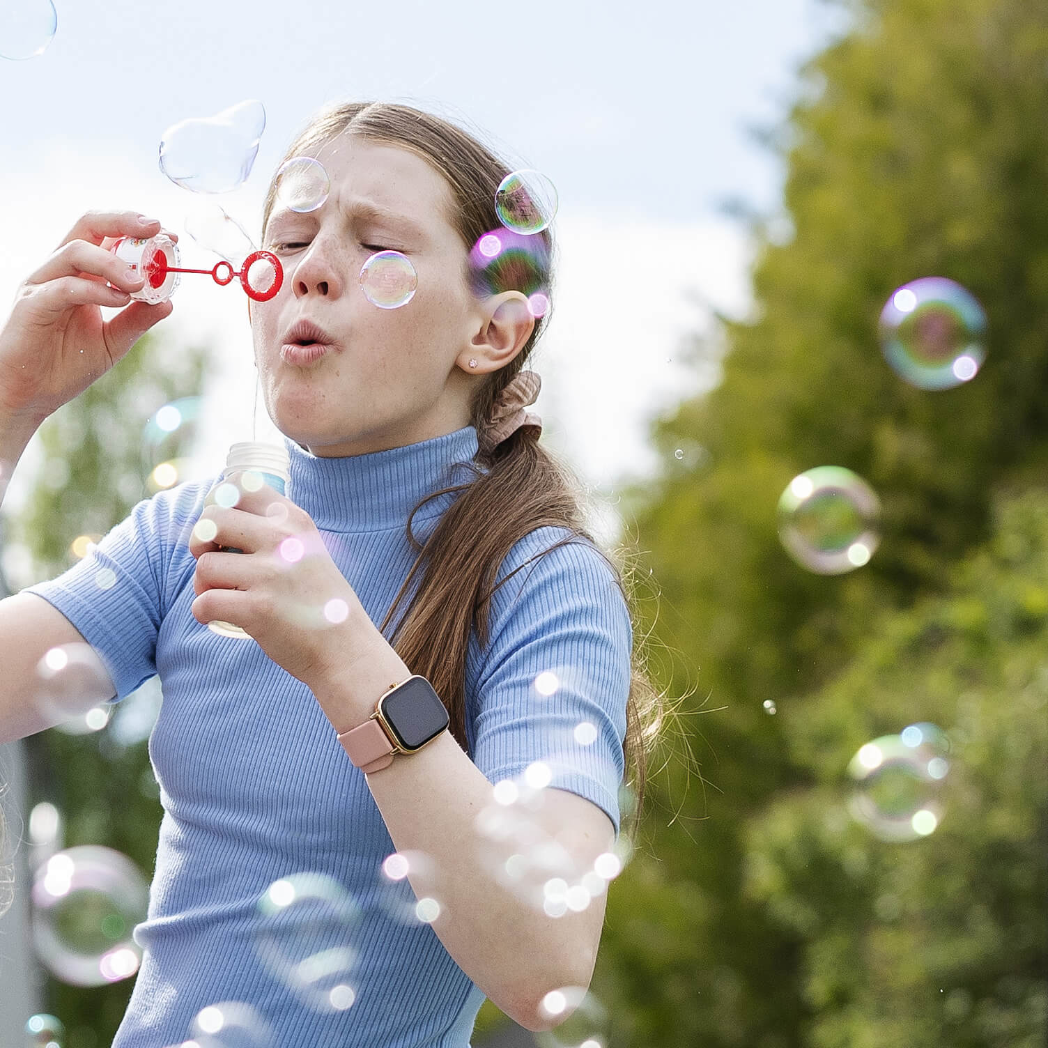 A girl blowing soap bubbles.