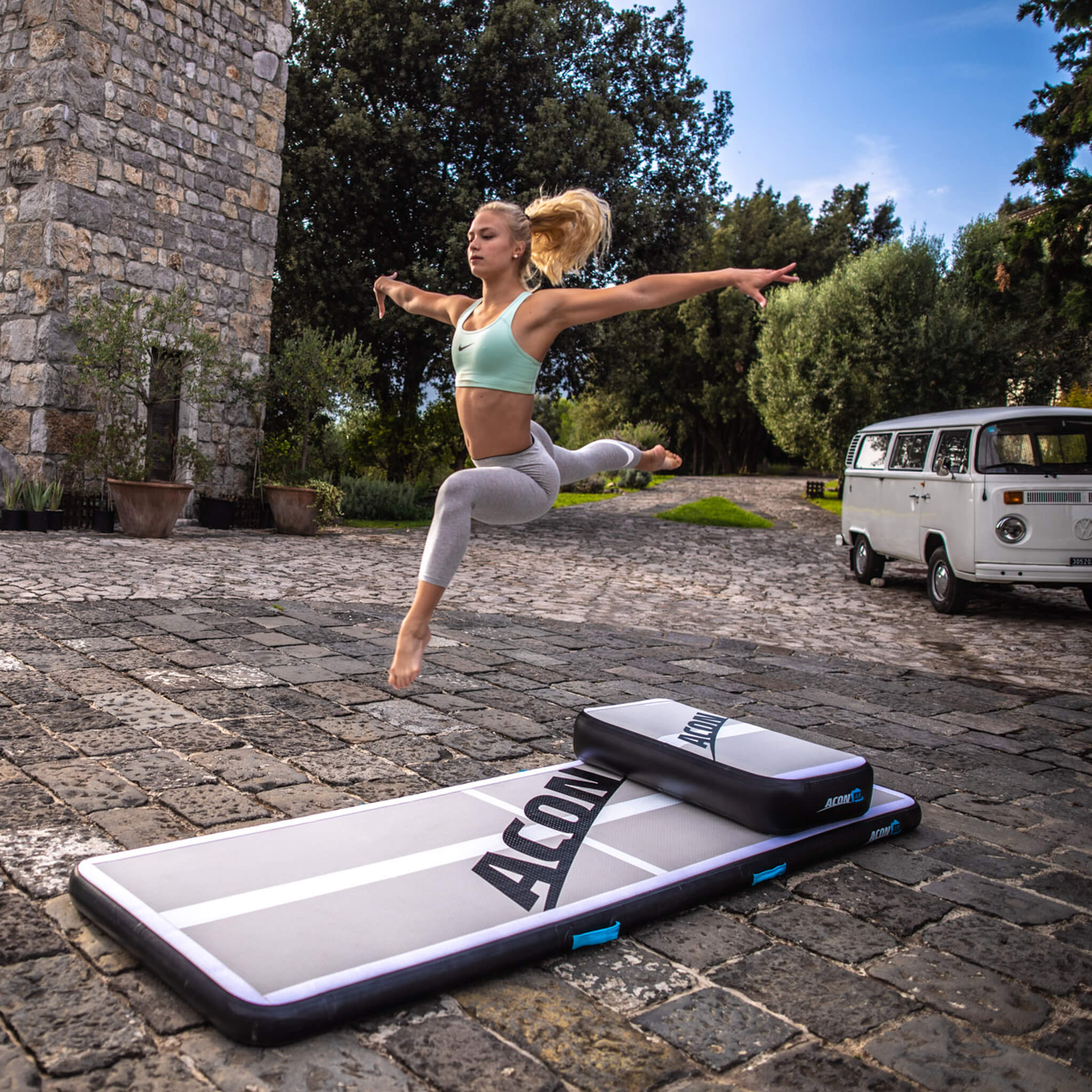 A gymnast jumps on top of an airtrack-airblock combo.