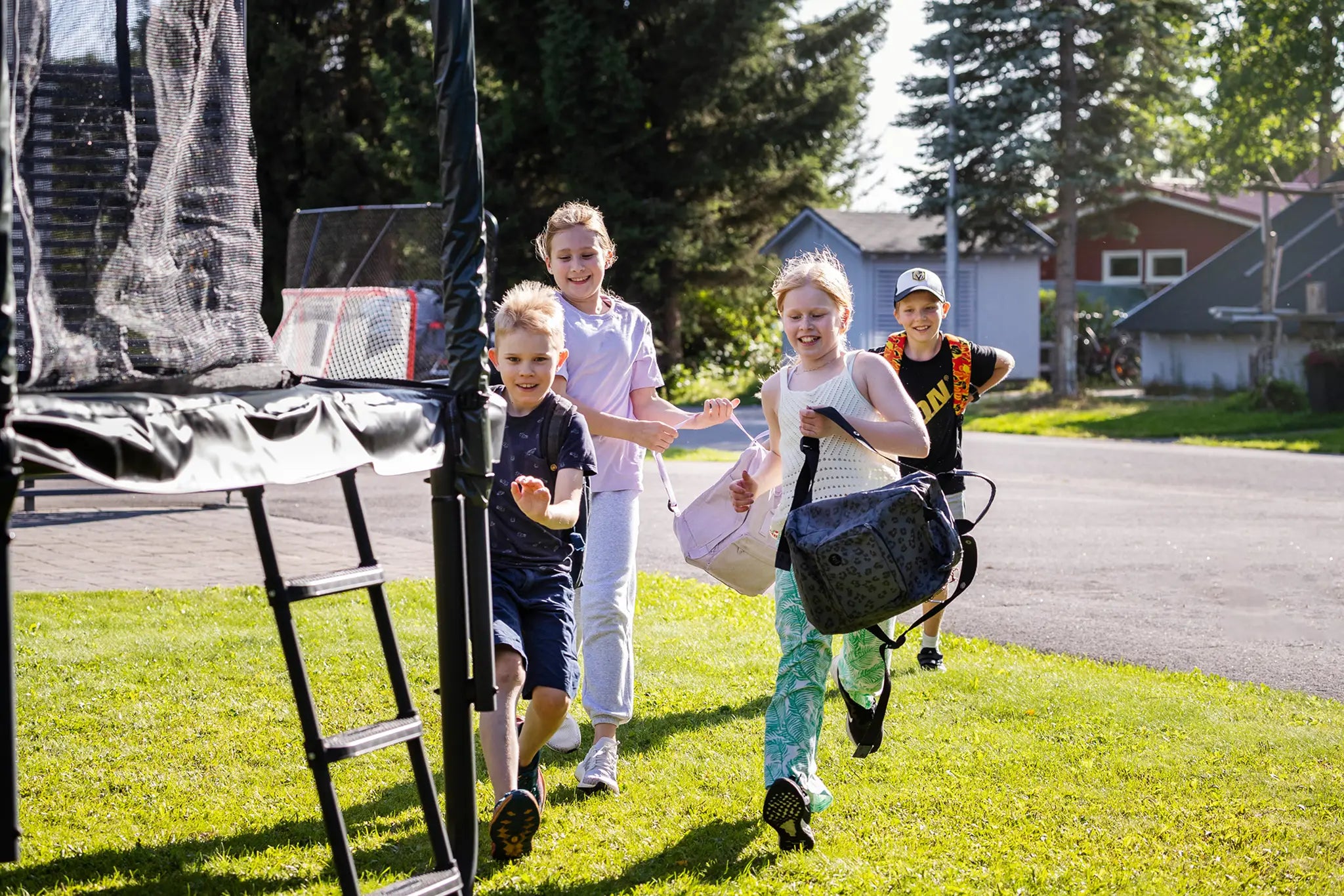 Kids running outside to the trampoline after school.