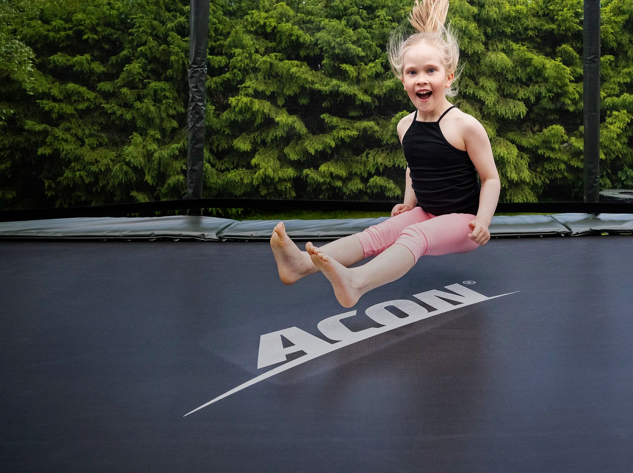 Little girl landing on the rectangular Acon trampoline.