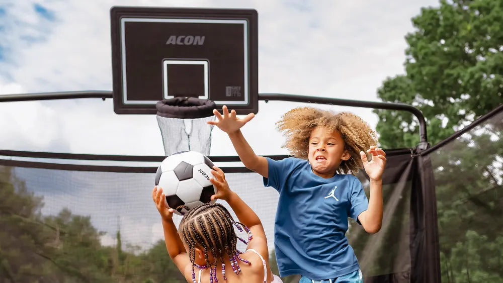 Children playing with the ACON Basketball Hoop on an Acon X trampoline.