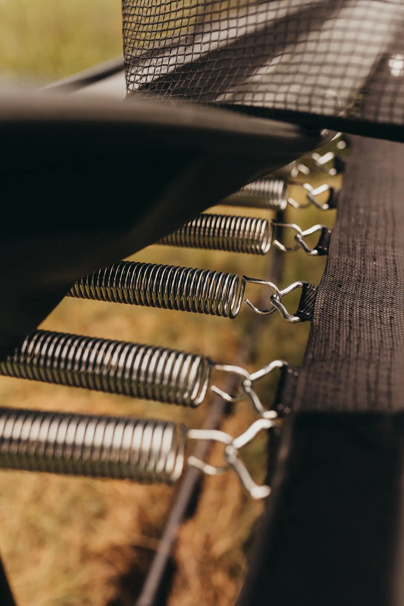 Close up picture of trampoline springs under the safety pad. 