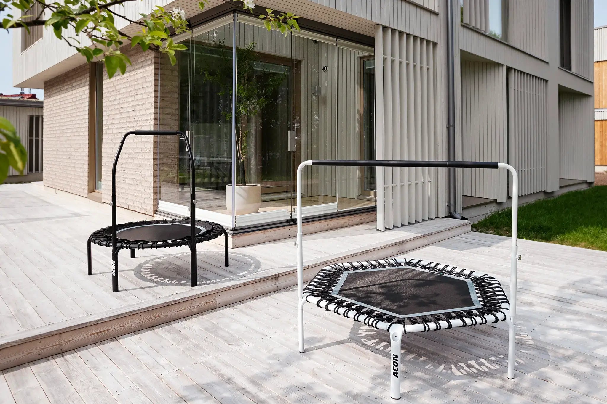 Two Acon rebounders with handlebars outside on a terrace. 